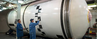 SLS Solid Rocket Booster Segment Being Painted by Two Men