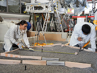 Engineers Marleen Sundgaard (left) and Pranay Mishra measure their test lander's "workspace" -- the terrain where scientists want to set InSight's instruments -- at NASA’s Jet Propulsion Laboratory in Pasadena, California. 